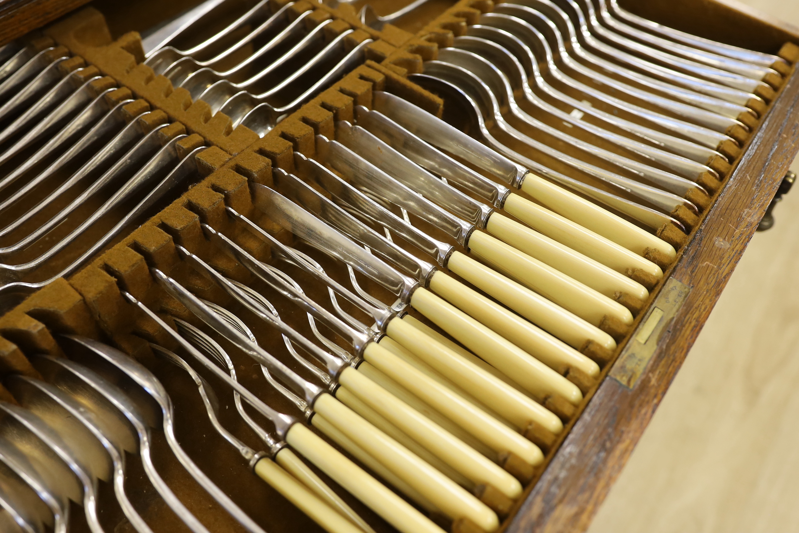 An oak standing canteen with two drawers of Mappin and Webb silver plated cutlery, settings for twelve people, 78cm high x 70cm wide x 54cm deep